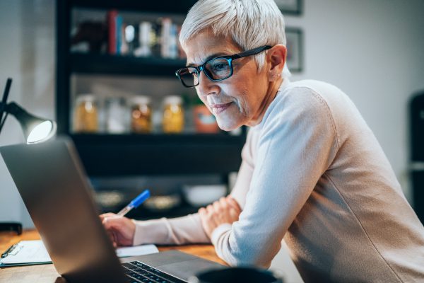 Senior woman working at home using lap top